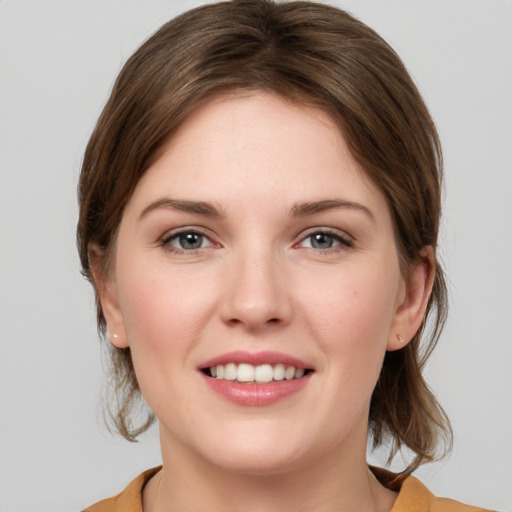 Joyful white young-adult female with medium  brown hair and grey eyes