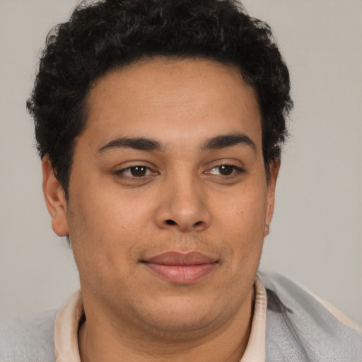 Joyful latino young-adult male with short  brown hair and brown eyes