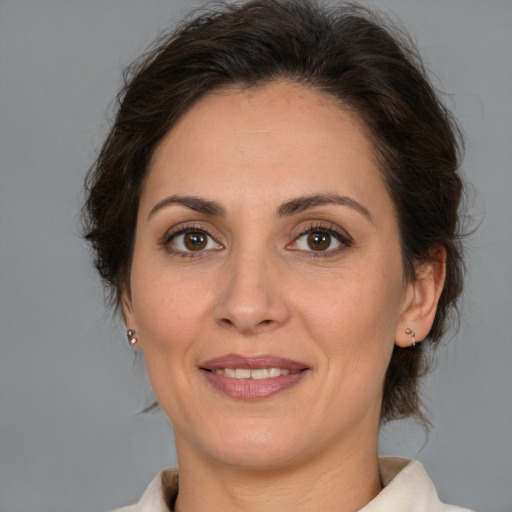 Joyful white adult female with medium  brown hair and brown eyes