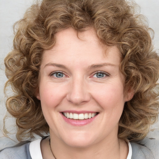 Joyful white young-adult female with medium  brown hair and blue eyes