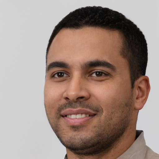 Joyful latino young-adult male with short  black hair and brown eyes