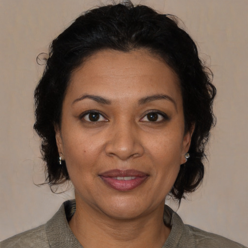 Joyful latino adult female with medium  brown hair and brown eyes