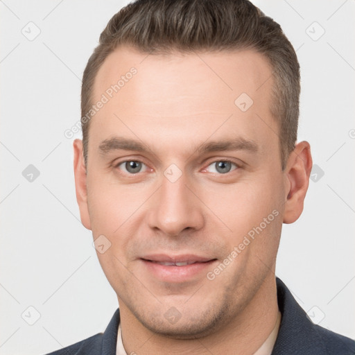 Joyful white young-adult male with short  brown hair and grey eyes