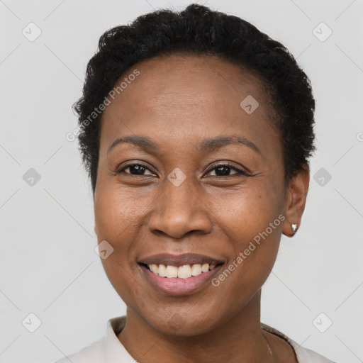 Joyful black young-adult female with short  black hair and brown eyes