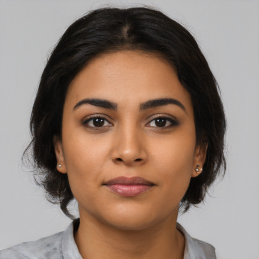 Joyful latino young-adult female with medium  brown hair and brown eyes