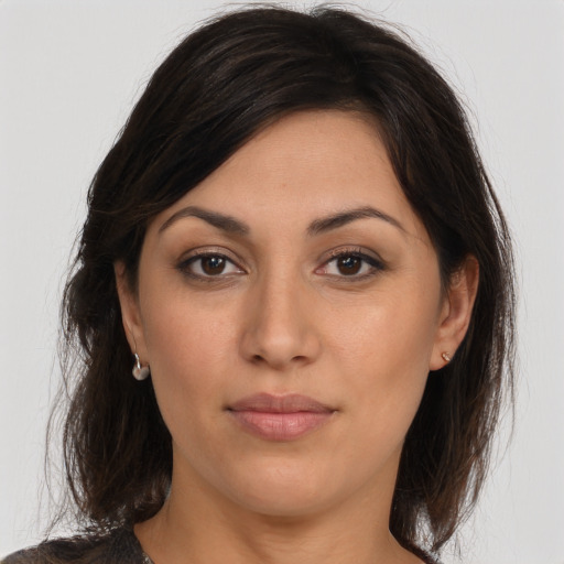 Joyful latino young-adult female with medium  brown hair and brown eyes