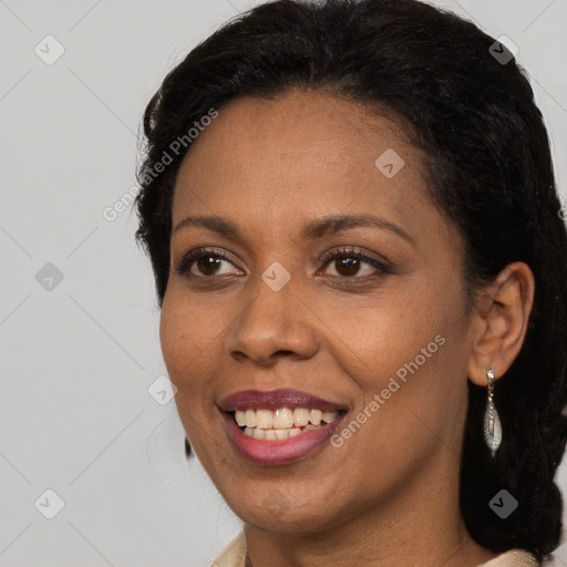 Joyful black adult female with long  brown hair and brown eyes