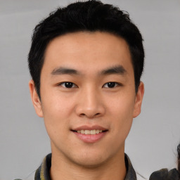 Joyful asian young-adult male with short  black hair and brown eyes