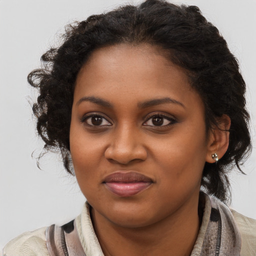 Joyful black young-adult female with long  brown hair and brown eyes
