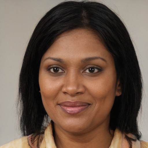 Joyful black adult female with medium  brown hair and brown eyes