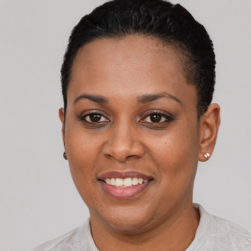 Joyful black young-adult female with short  black hair and brown eyes