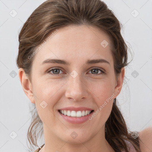 Joyful white young-adult female with medium  brown hair and grey eyes