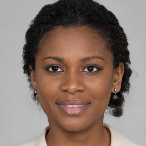 Joyful black young-adult female with short  brown hair and brown eyes