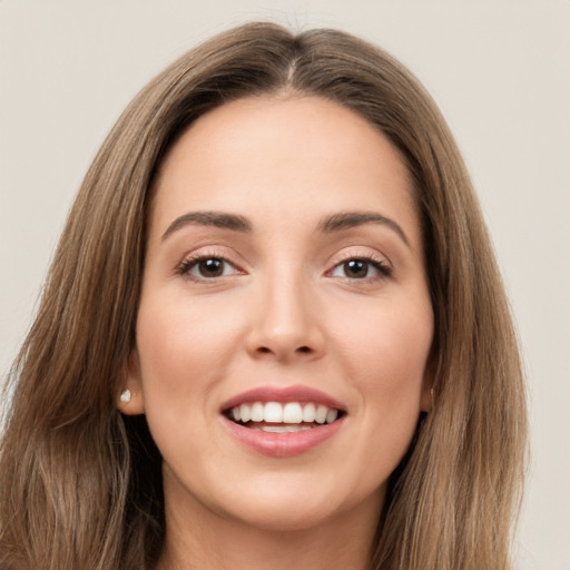 Joyful white young-adult female with long  brown hair and brown eyes