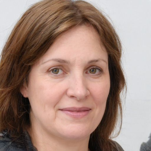 Joyful white adult female with medium  brown hair and grey eyes