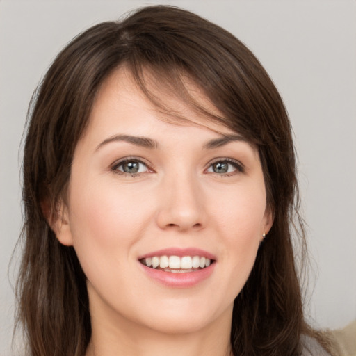 Joyful white young-adult female with long  brown hair and grey eyes