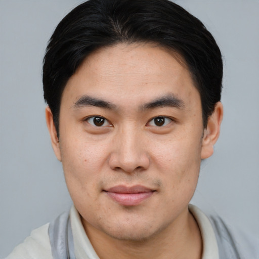 Joyful asian young-adult male with short  brown hair and brown eyes
