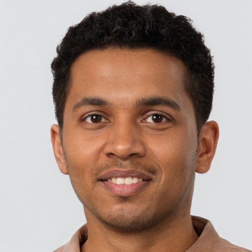 Joyful black young-adult male with short  brown hair and brown eyes
