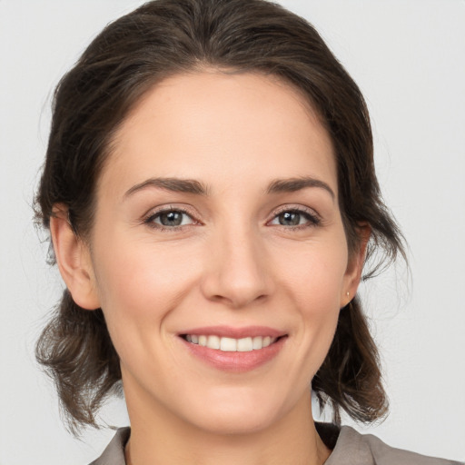 Joyful white young-adult female with medium  brown hair and brown eyes