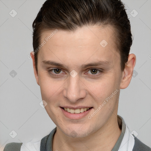 Joyful white young-adult male with short  brown hair and grey eyes