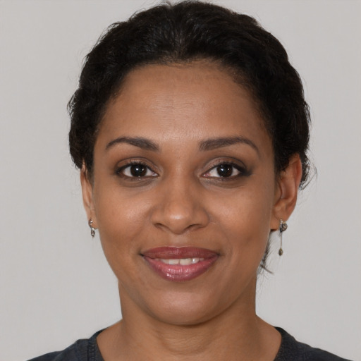 Joyful black young-adult female with short  brown hair and brown eyes