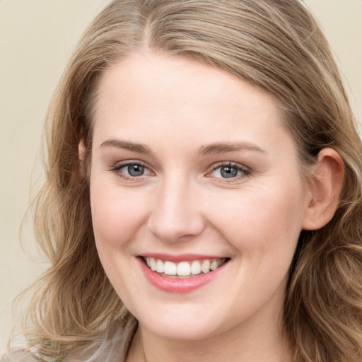 Joyful white young-adult female with long  brown hair and blue eyes