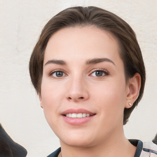 Joyful white young-adult female with medium  brown hair and grey eyes