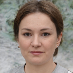 Joyful white young-adult female with medium  brown hair and grey eyes