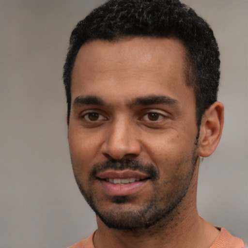 Joyful black young-adult male with short  black hair and brown eyes