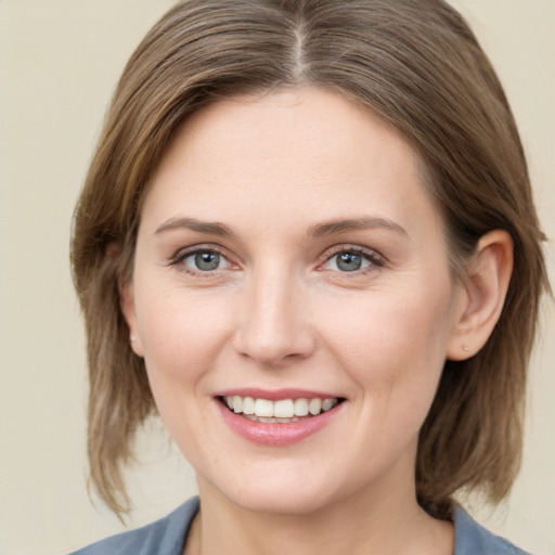 Joyful white young-adult female with medium  brown hair and grey eyes