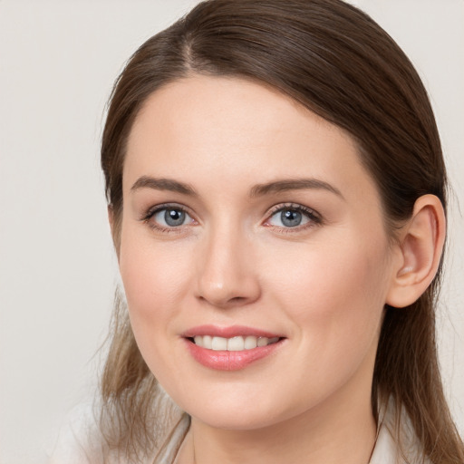 Joyful white young-adult female with medium  brown hair and grey eyes