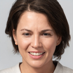 Joyful white adult female with medium  brown hair and brown eyes