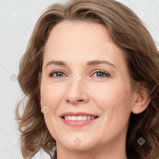 Joyful white adult female with long  brown hair and grey eyes