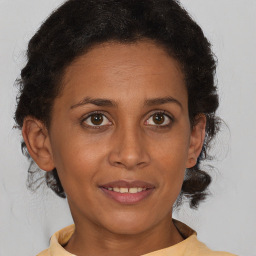 Joyful black adult female with medium  brown hair and brown eyes