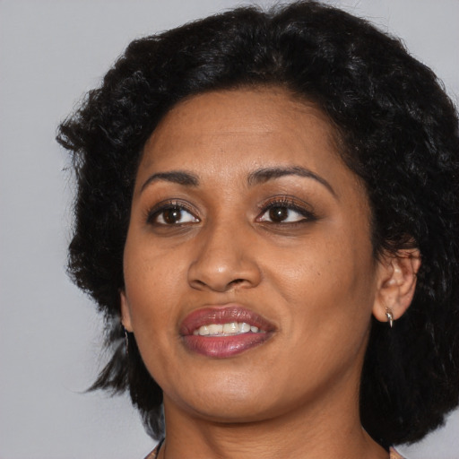 Joyful black young-adult female with medium  black hair and brown eyes