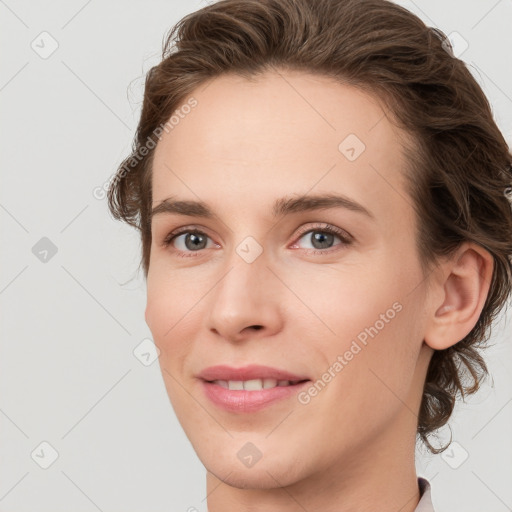 Joyful white young-adult female with medium  brown hair and grey eyes