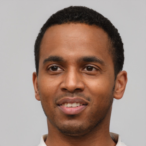 Joyful black young-adult male with short  black hair and brown eyes
