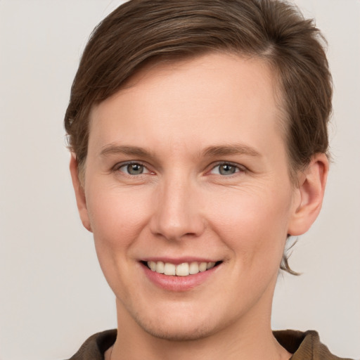 Joyful white young-adult female with short  brown hair and grey eyes