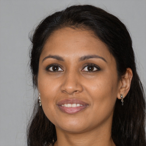 Joyful black young-adult female with long  brown hair and brown eyes