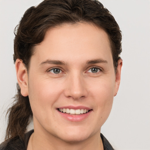 Joyful white young-adult female with short  brown hair and grey eyes