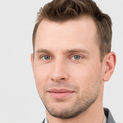 Joyful white young-adult male with short  brown hair and grey eyes