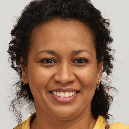 Joyful black adult female with long  brown hair and brown eyes