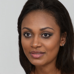 Joyful black young-adult female with long  brown hair and brown eyes