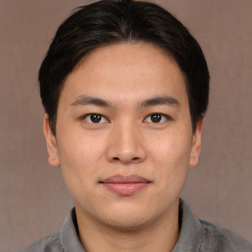 Joyful asian young-adult male with medium  brown hair and brown eyes