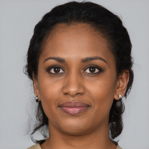 Joyful black young-adult female with medium  black hair and brown eyes