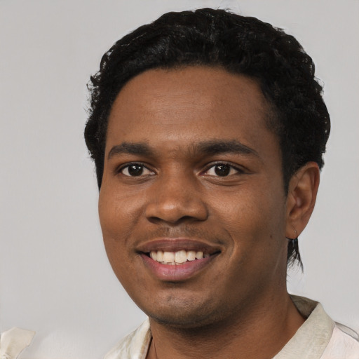 Joyful black young-adult male with short  black hair and brown eyes