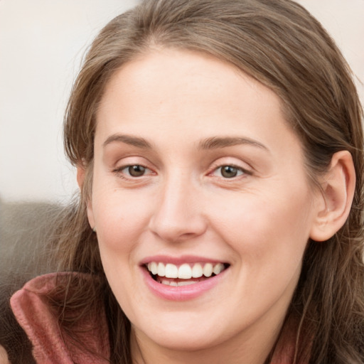 Joyful white young-adult female with long  brown hair and blue eyes