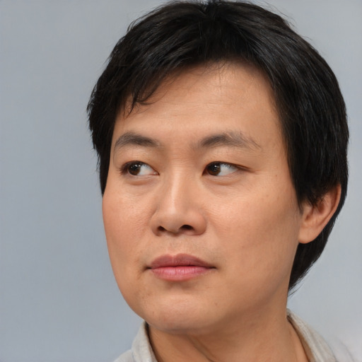 Joyful asian young-adult male with short  black hair and brown eyes