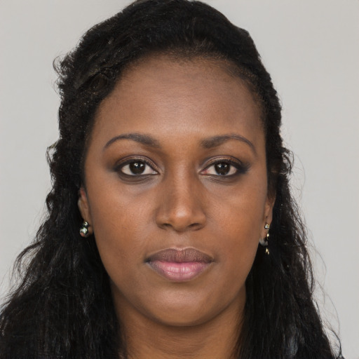 Joyful black young-adult female with long  black hair and brown eyes
