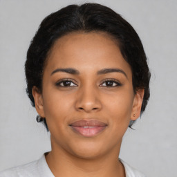 Joyful latino young-adult female with medium  brown hair and brown eyes